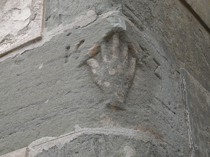 Escut amb la mà de Manlleu i la data 1582. Situat a la cantonada entre el carrer Rossell i carrer Torelló, a la sortida del barri de Dalt Vila
