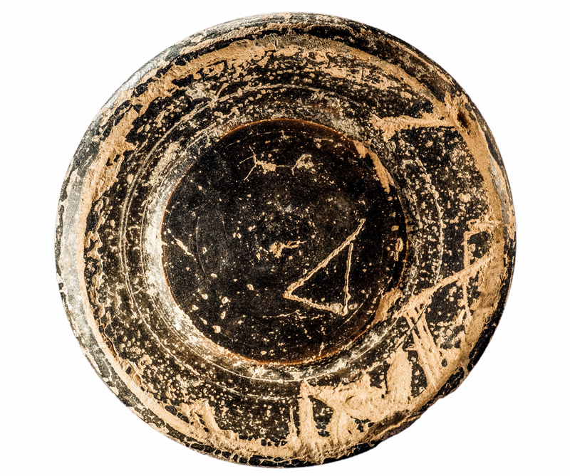 MIT: 10004. Fons de píxide de ceràmica de vernís negre amb signe ibèric inscrit (semblant a un triangle) en posterioritat a la cocció (100-25 aC). Hi havia el costum que el propietari o propietària marqués les peces. Can Caseta.